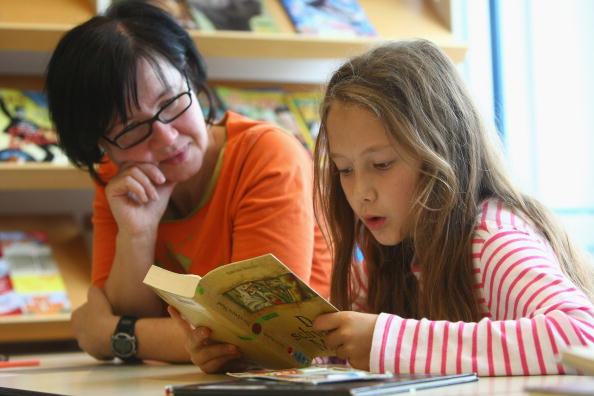 girl reading to woman